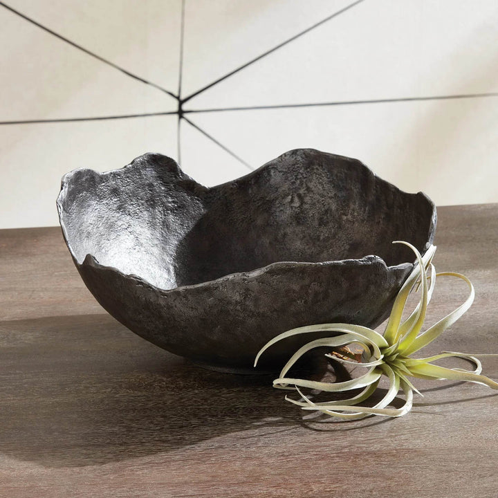 Close-up of black aluminum bowl with textured surface and curved rim, ideal as a large decorative centerpiece for dining tables