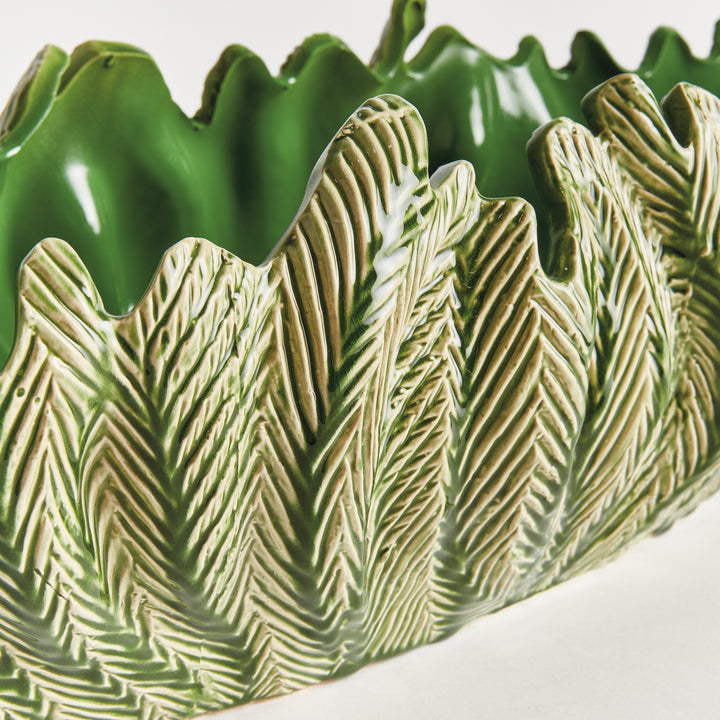 Detail of decorative oval bowl in green with carved frond texture and handcrafted clay finish artisan style