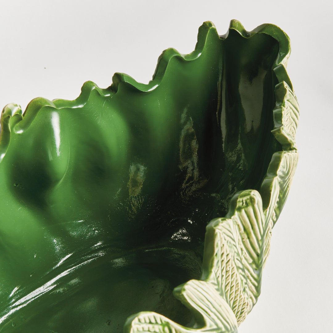 Close view of decorative oval bowl in green showing glossy reactive glaze interior sculpted clay style