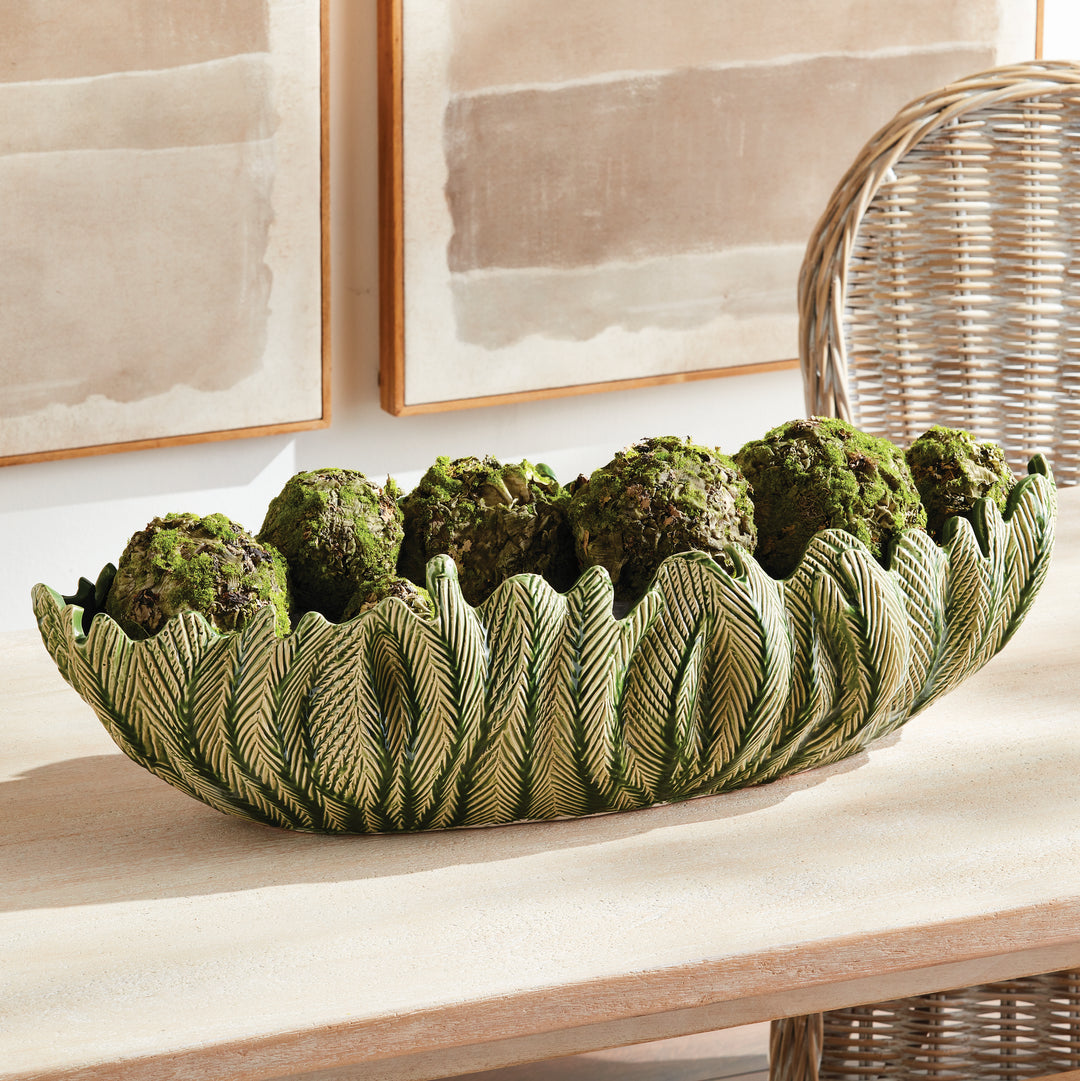 Large decorative oval bowl in green styled on console with natural accents sculpted centerpiece décor style