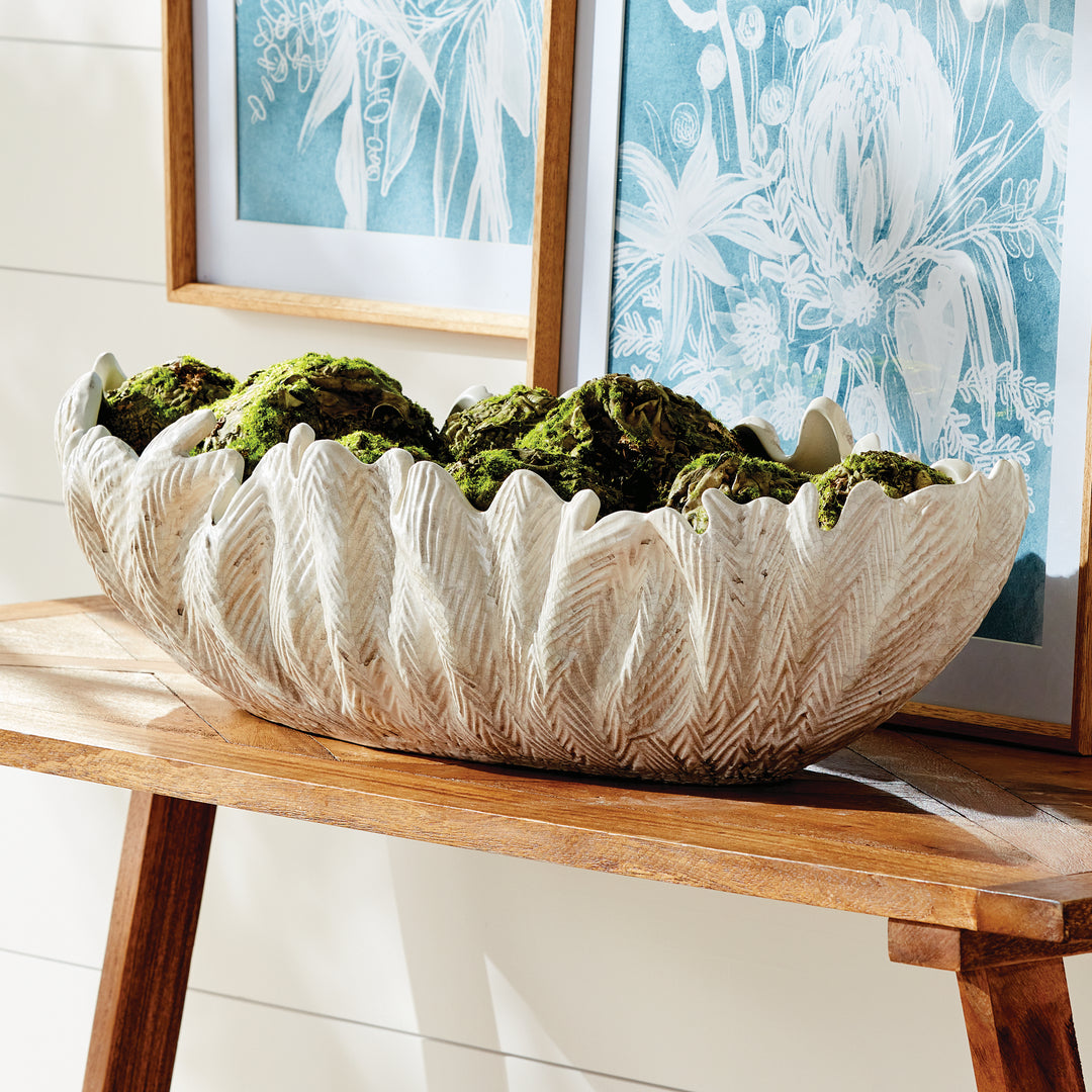 Large decorative oval bowl in ivory styled on console with greenery sculpted clay centerpiece décor style