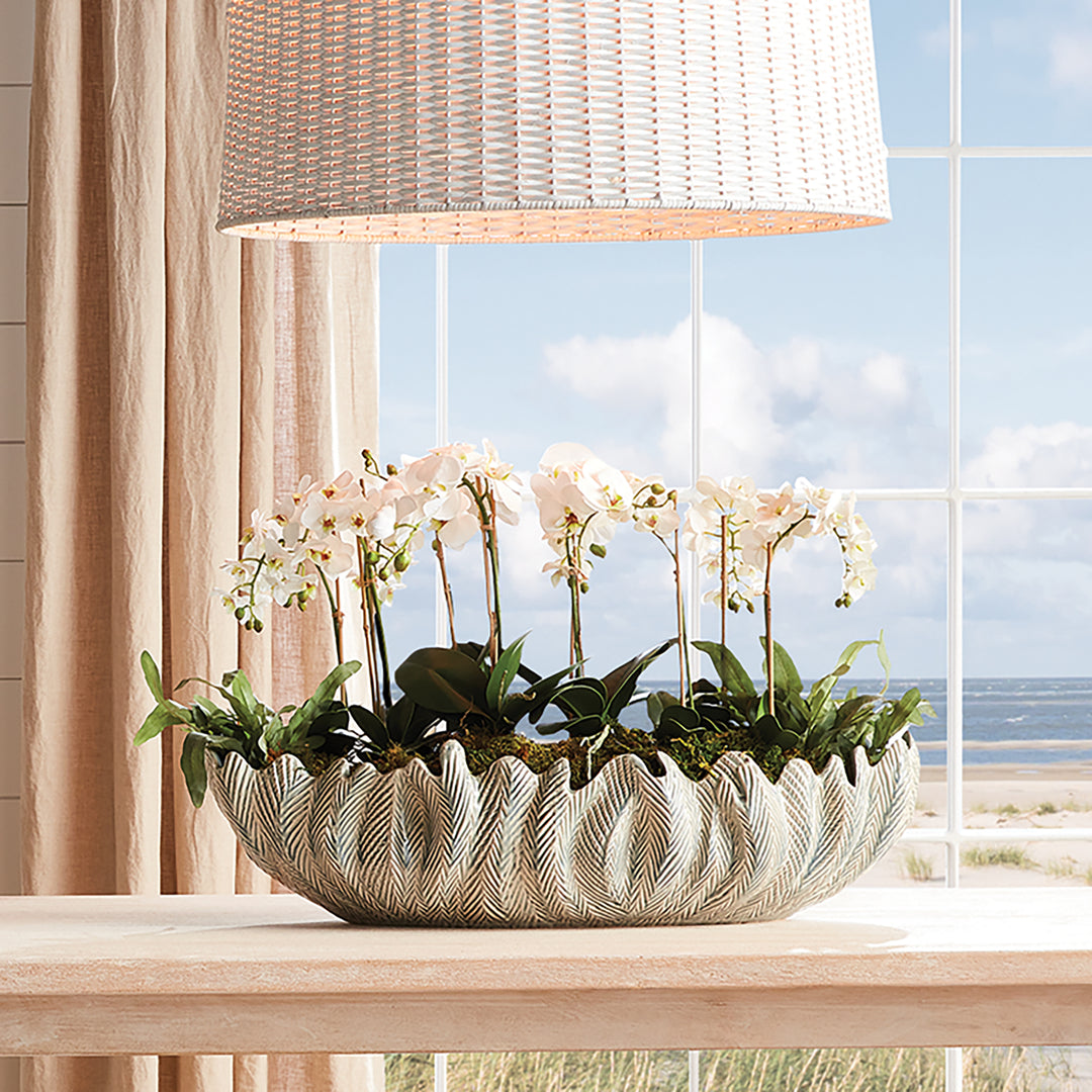 Large decorative oval bowl in ivory styled on shelf with greenery sculpted clay centerpiece décor style