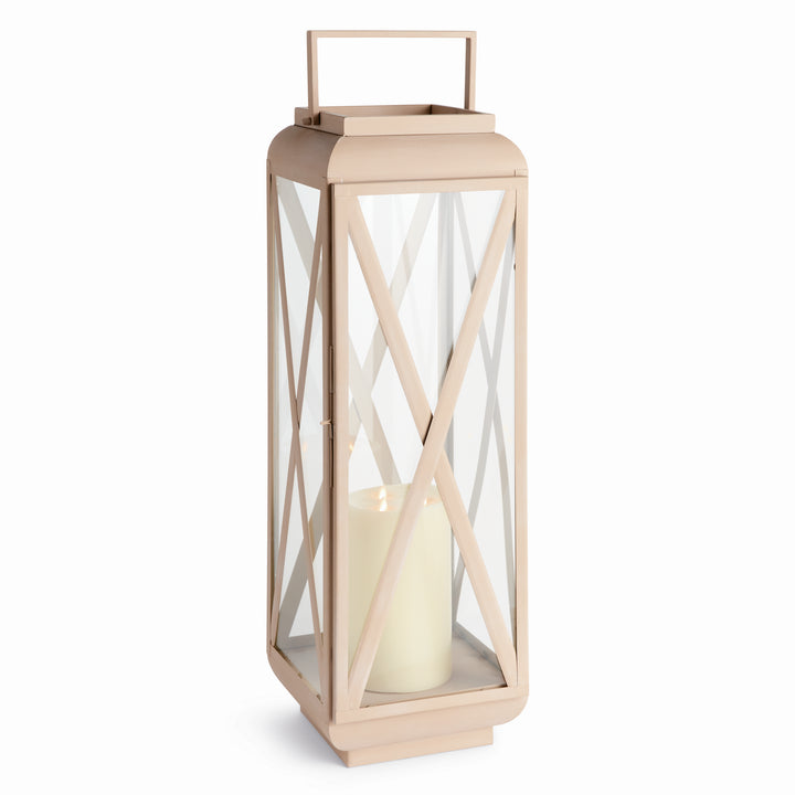 Side angle of glass outdoor candle lantern highlighting sandstone-look iron frame and clear glass panels, Modern Organic style