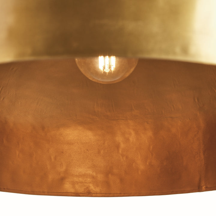 Interior view of large gold iron dome pendant light showing downward light direction, socket placement, and warm metal interior. Contemporary
