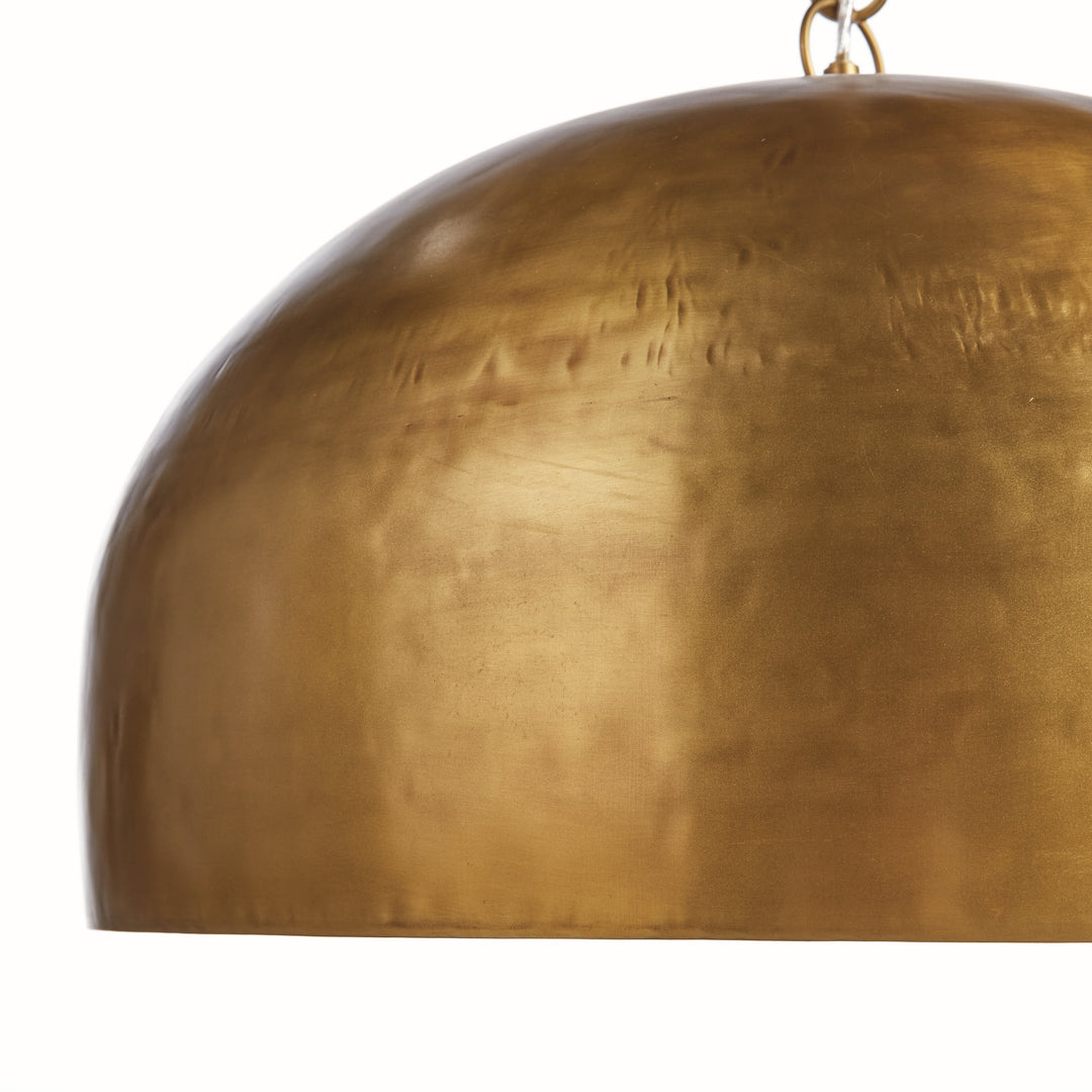 Side detail of large gold iron dome pendant light highlighting curved silhouette and textured metal surface finish. Contemporary