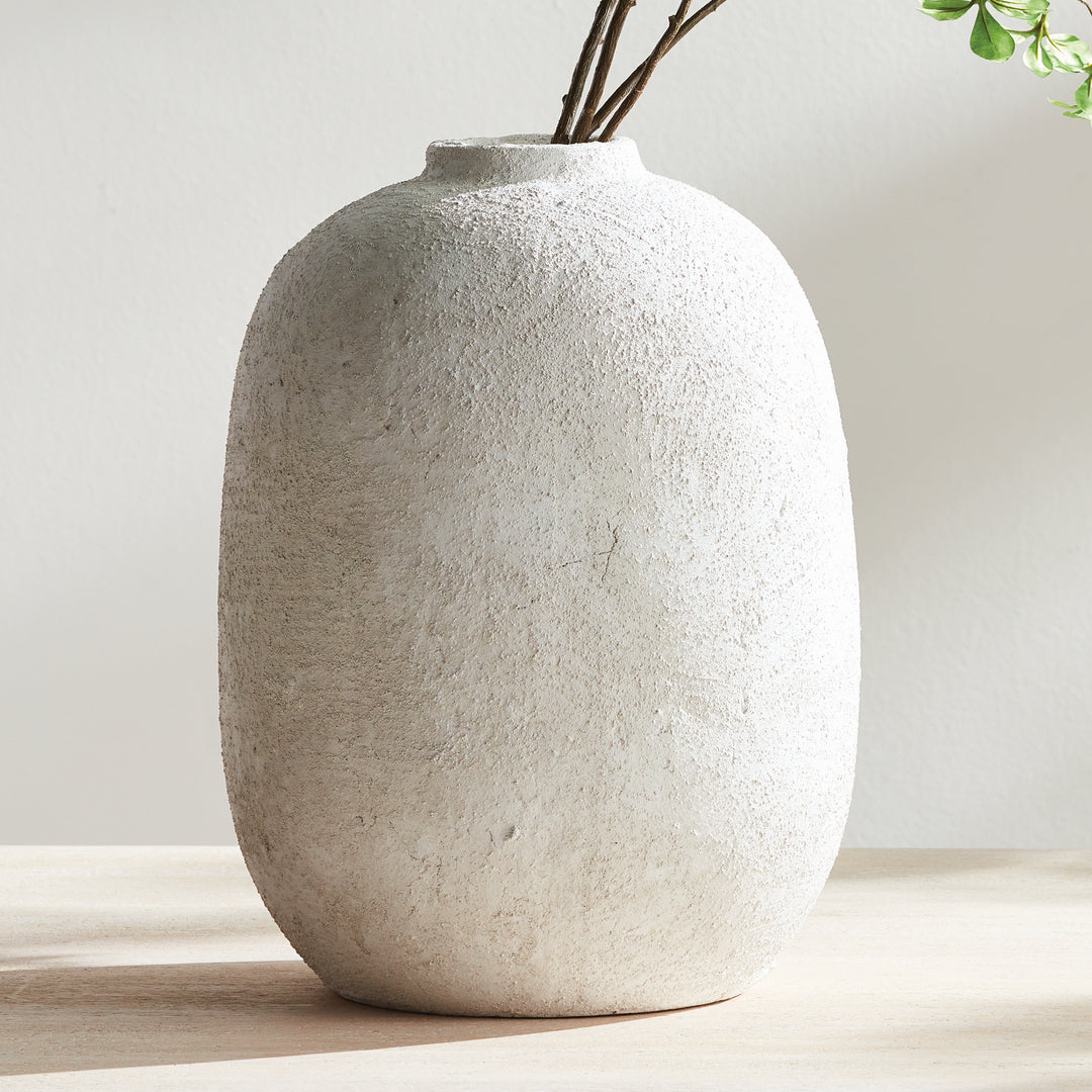 Large gray terracotta vase with textured surface styled on table with branches, handcrafted finish and rounded form – Transitional