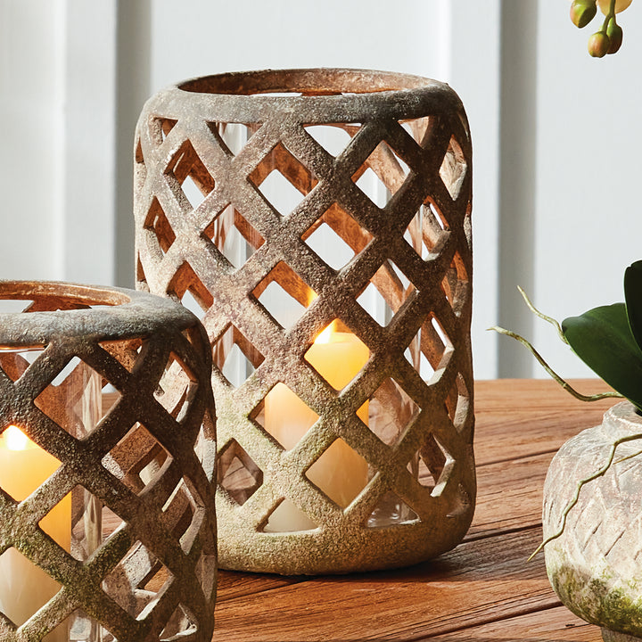 Large moss terracotta hurricane candle holder styled on wood table with candlelight – European Transitional style.