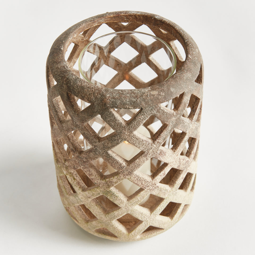 Front angled view of large white terracotta hurricane candle holder with lattice cutouts – Coastal Transitional style.