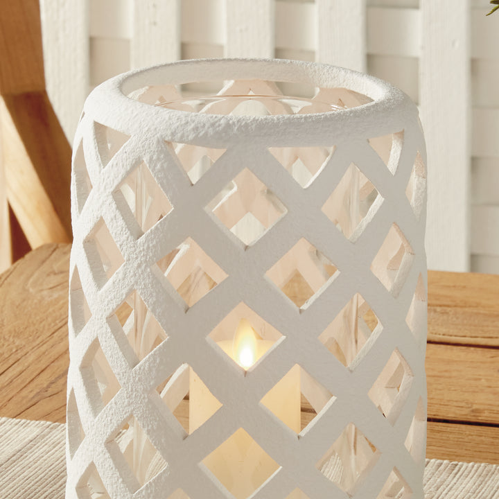 Large white terracotta hurricane candle holder styled on tabletop with warm candlelight – Coastal Transitional style.