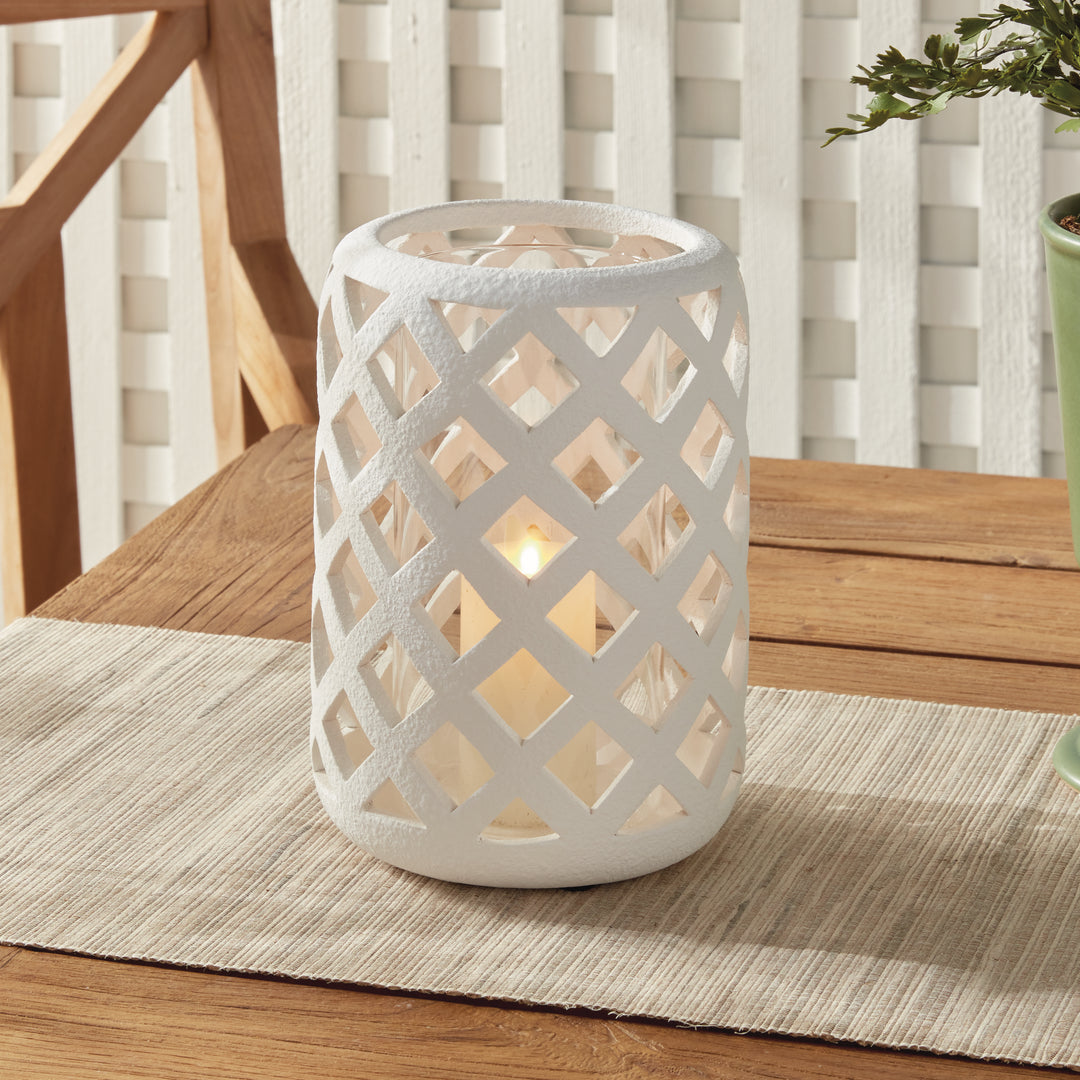 Large white terracotta hurricane candle holder styled on wood tabletop with candlelight – Modern Organic style.