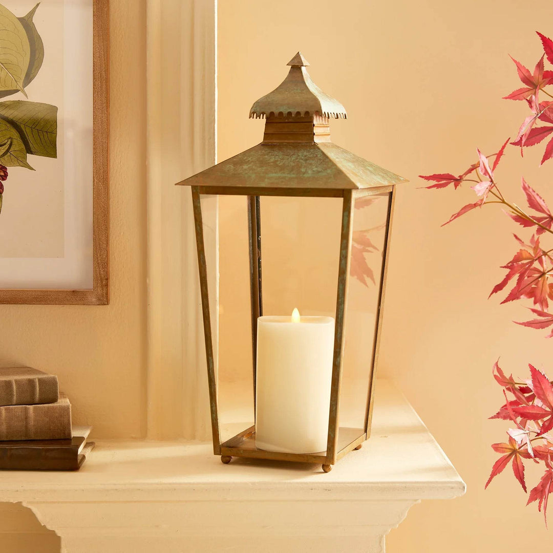 Large patina metal lantern with pagoda top styled on console with candlelight, aged finish and clear glass panels – Transitional, Rustic, Asian-Inspired
