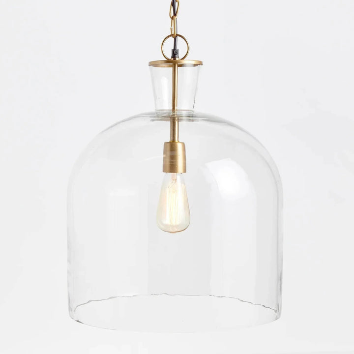 Angled view of large clear glass bell pendant shade, showing curved shoulders and brass-finished fittings, Transitional style
