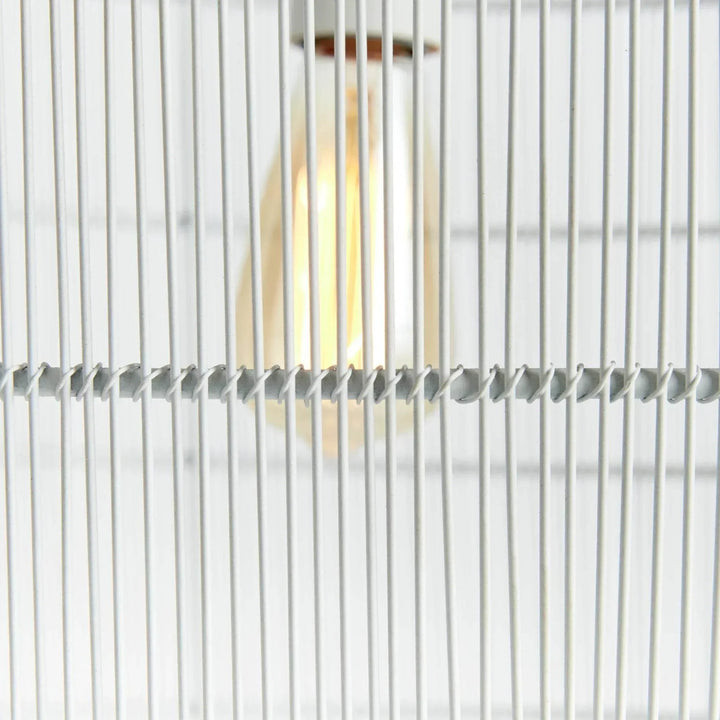 Detail of the large white woven iron pendant light with an exposed bulb visible behind slim vertical strands, Coastal style