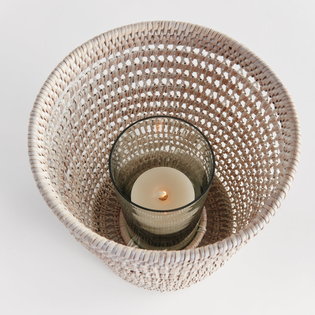 Top view into a large whitewash rattan hurricane showing a candle inside its glass insert and the woven sides, Transitional