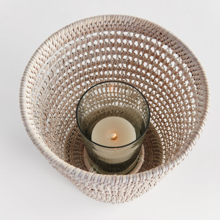 Top view into a large whitewash rattan hurricane showing a candle inside its glass insert and the woven sides, Transitional