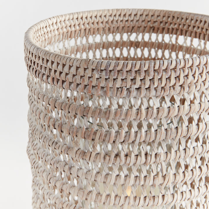 Close view of a large whitewash rattan hurricane showing the woven upper rim and open pattern against white, Transitional