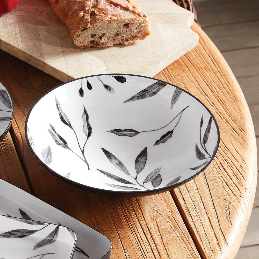 Black and white leaf serving bowl on a wood table with bread, showcasing modern enamel finish for stylish serving or decor – Modern Minimal.

