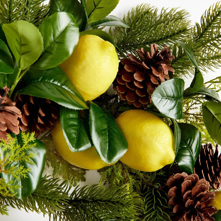 Faux citrus and pinecones surrounded by dark green foliage – right side detail

