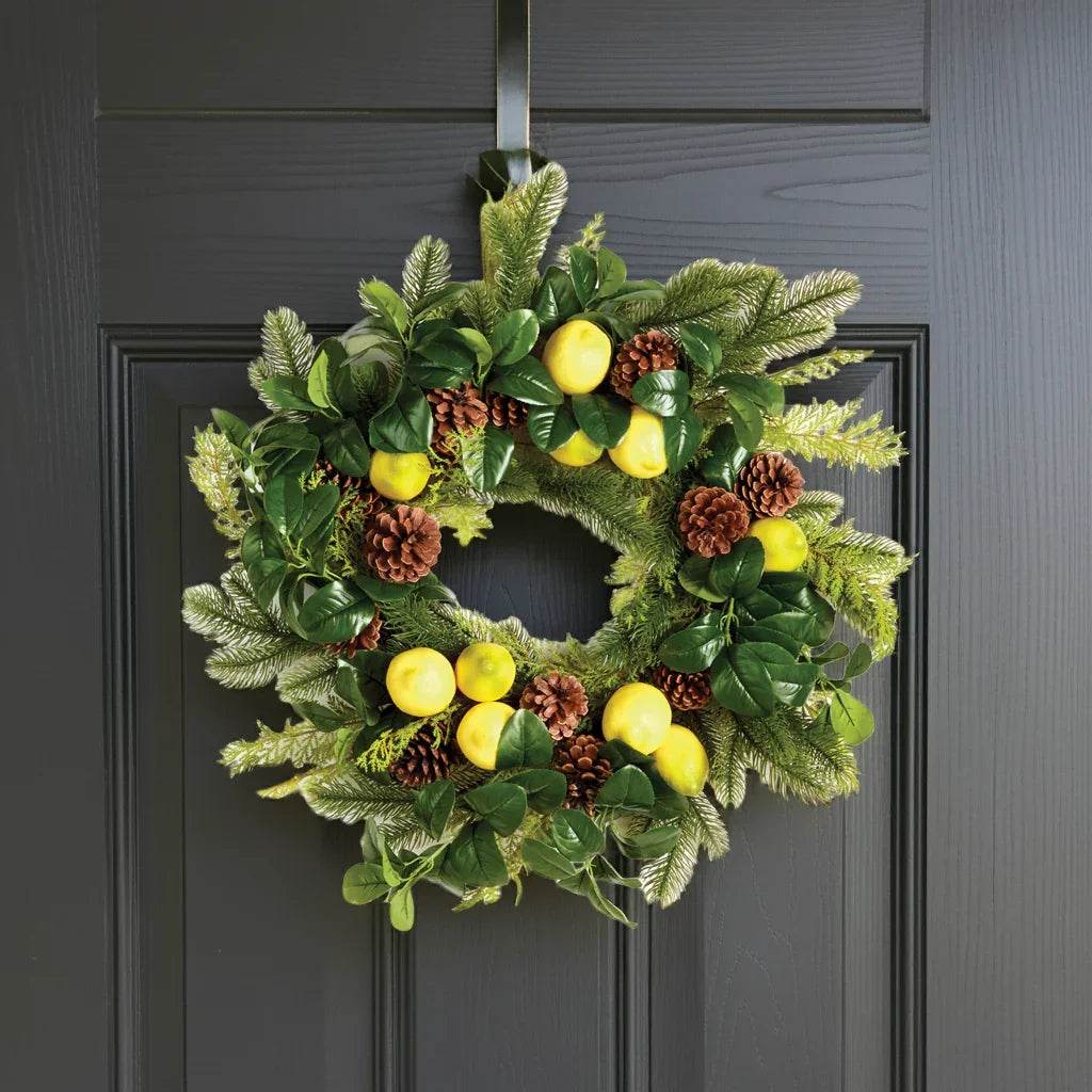 Lemon and evergreen wreath hanging on a dark front door – welcoming seasonal display