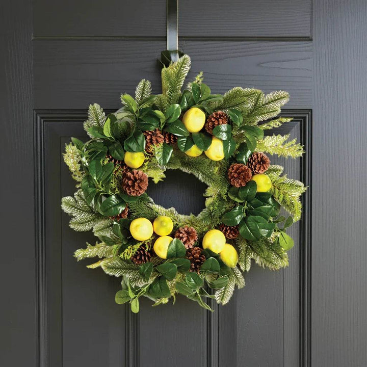 Lemon and evergreen wreath hanging on a dark front door – welcoming seasonal display
