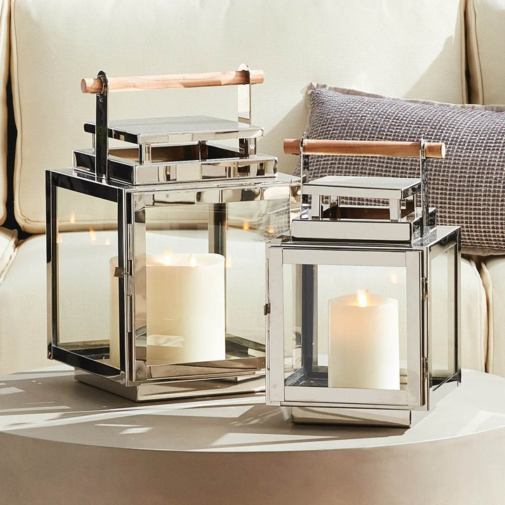 Small modern coastal lantern in silver with teak handle styled on patio seating area