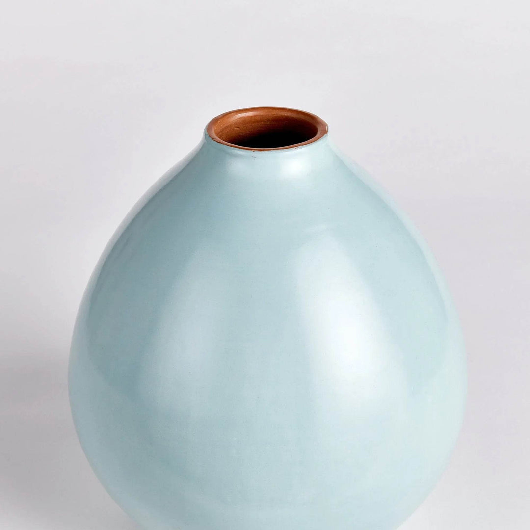 Light blue ceramic vase shown in soft side profile highlighting curved form and brown rim – Modern Organic.