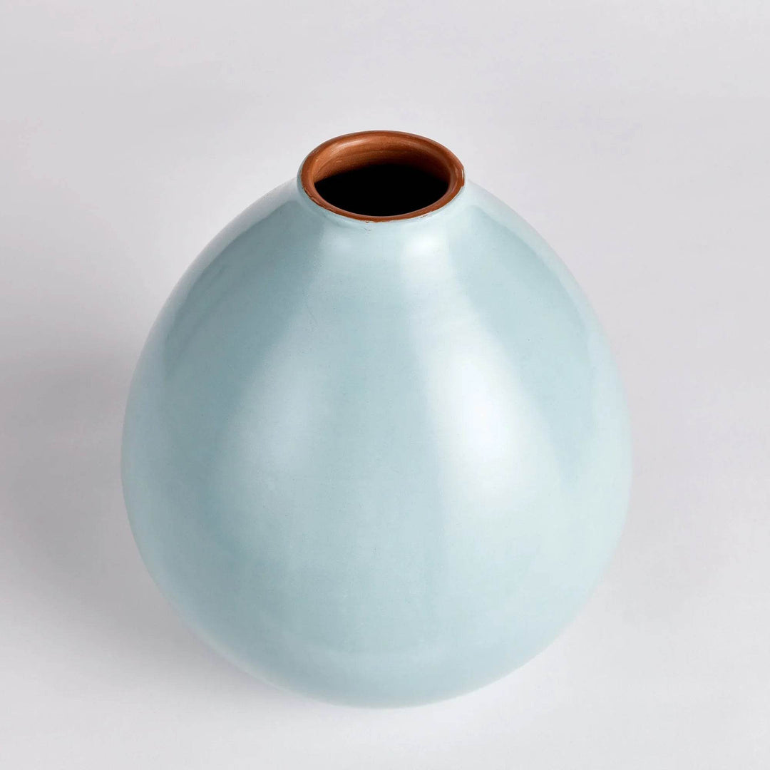 Top-down view of round light blue ceramic vase with rich brown interior and soft matte surface – Modern Organic.