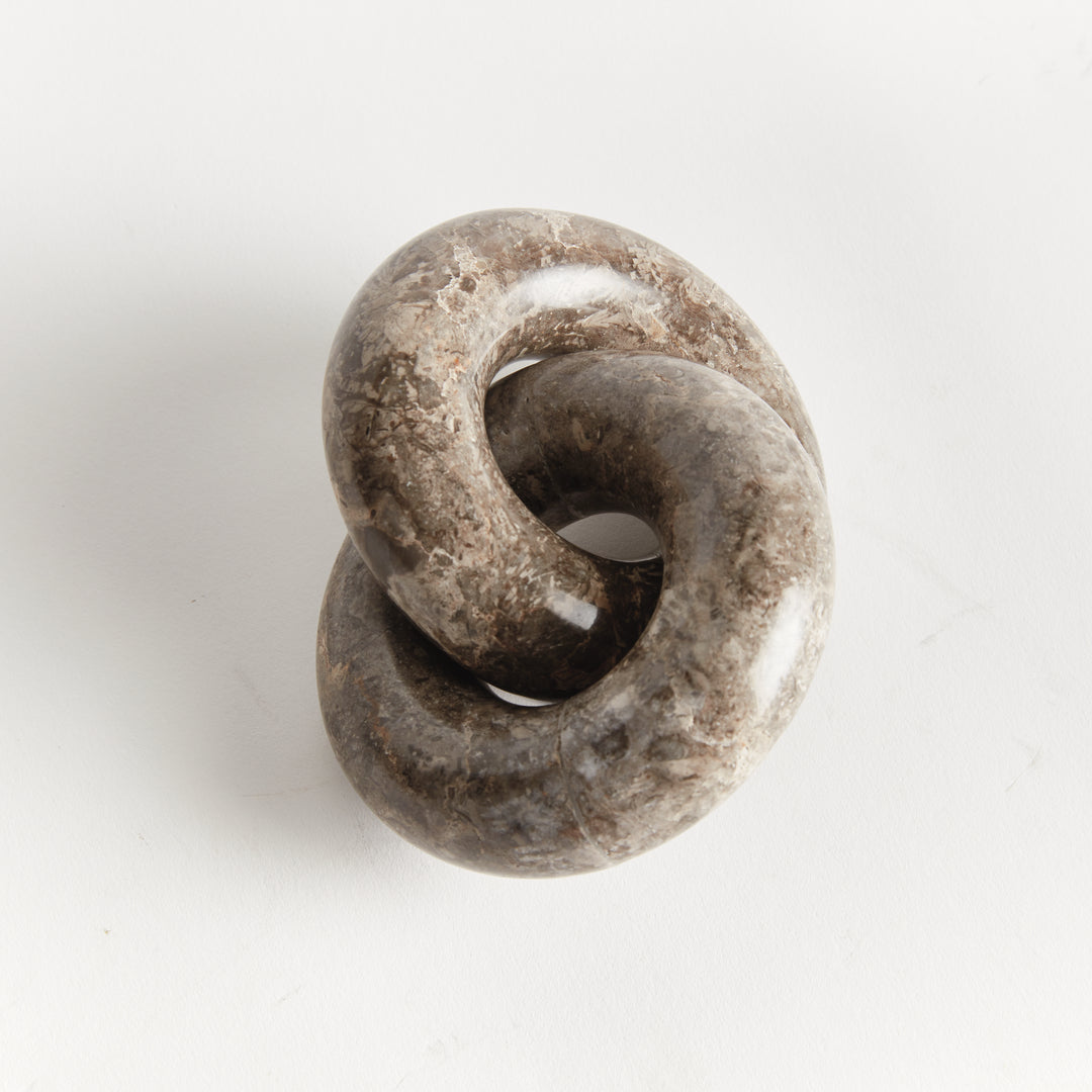 Linked marble rings sculpture viewed from above, showing the interlocking form and natural brown veining - Modern Organic