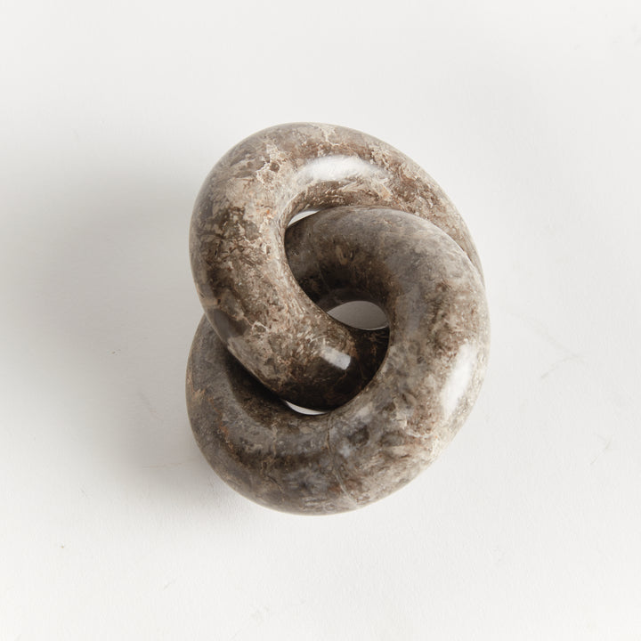 Linked marble rings sculpture viewed from above, showing the interlocking form and natural brown veining - Modern Organic