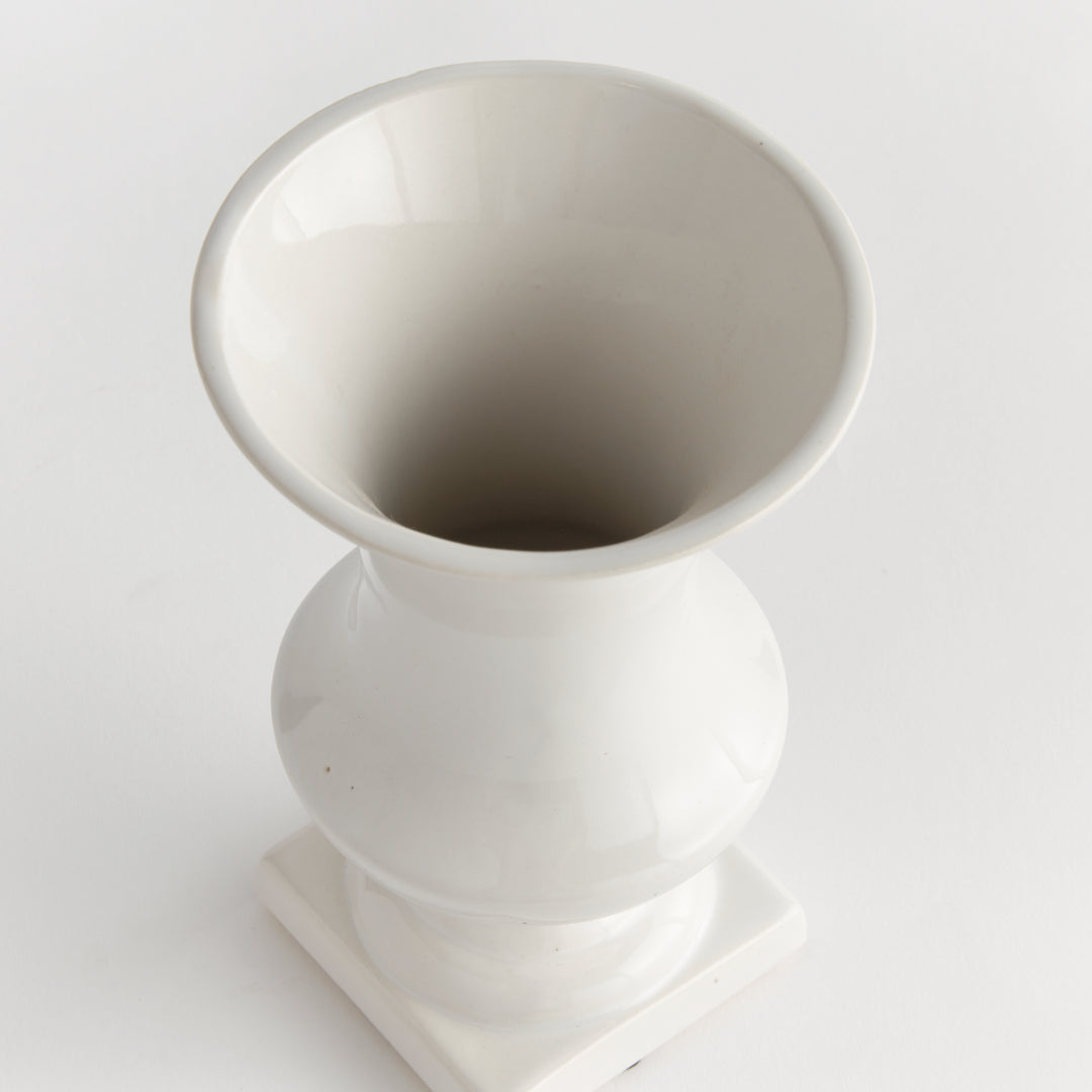 Overhead view of a small white ceramic trumpet vase showing its flared opening, body and square foot in Traditional style