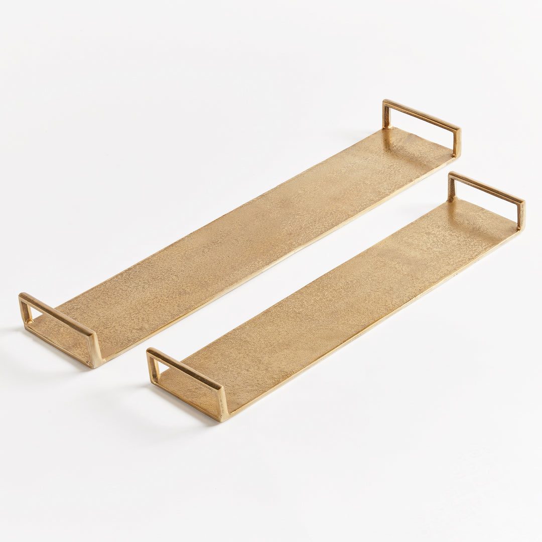 Set of two long narrow gold cast aluminum decorative trays with open rectangular handles on a white backdrop – Transitional.