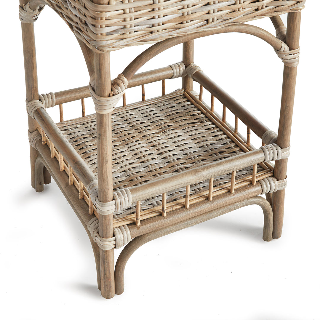 Close-up of lower basket shelf on three-tier rattan unit, highlighting coastal boho design and craftsmanship.