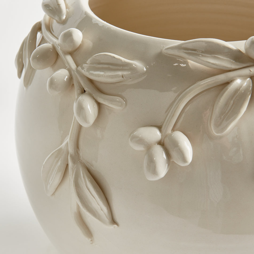 Close-up detail of handmade olive fruits, leaves and branches applied to a white glazed Italian ceramic vase. Traditional
