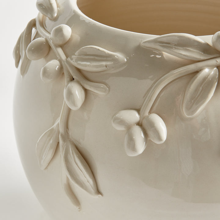 Close-up detail of handmade olive fruits, leaves and branches applied to a white glazed Italian ceramic vase. Traditional