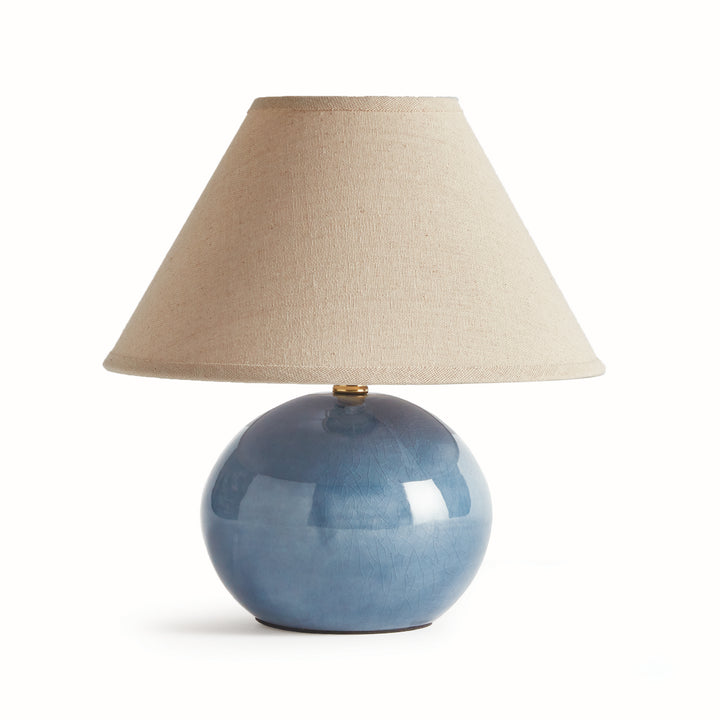 Blue mini ceramic table lamp with linen shade and glossy ceramic base on white background modern accent lighting style