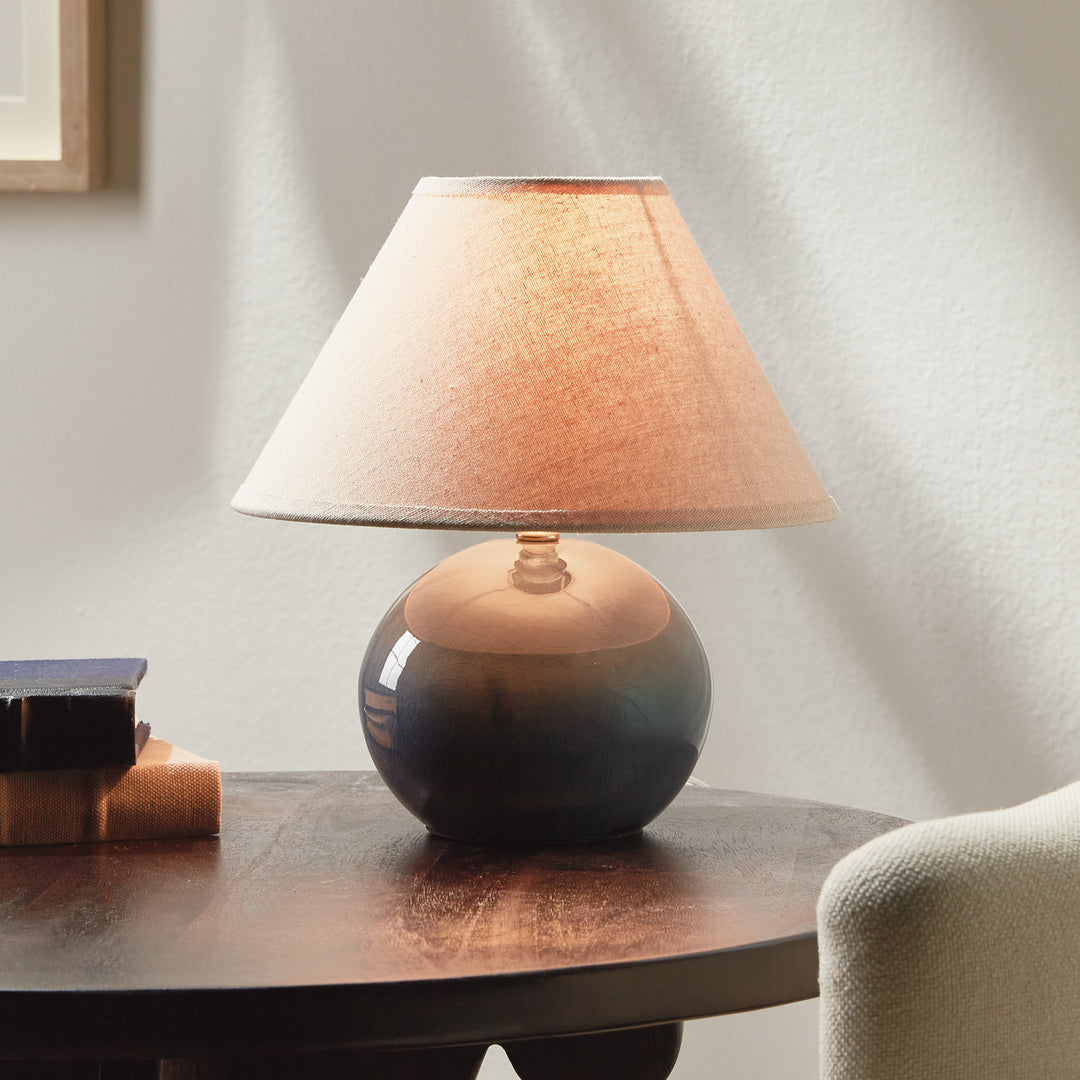 Gray mini ceramic table lamp illuminated on bedside table in bedroom setting modern accent lighting style