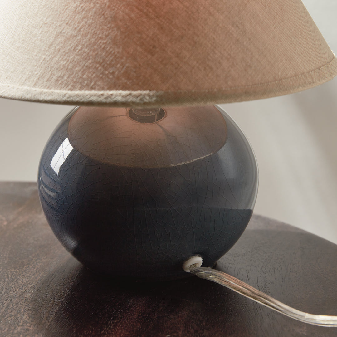 Gray mini ceramic table lamp closeup with linen shade and dark crackle glaze base modern accent lighting style