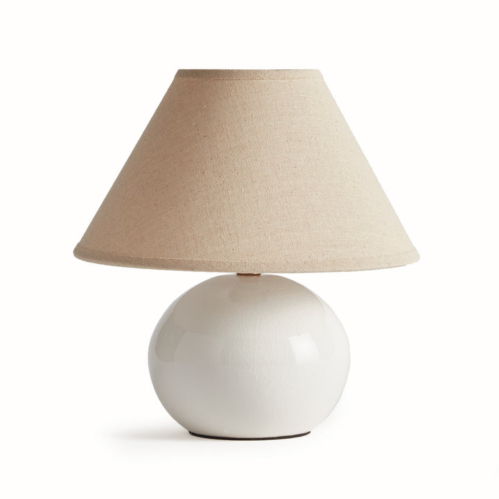White mini ceramic table lamp with linen shade and rounded ceramic base on white background modern accent lighting style