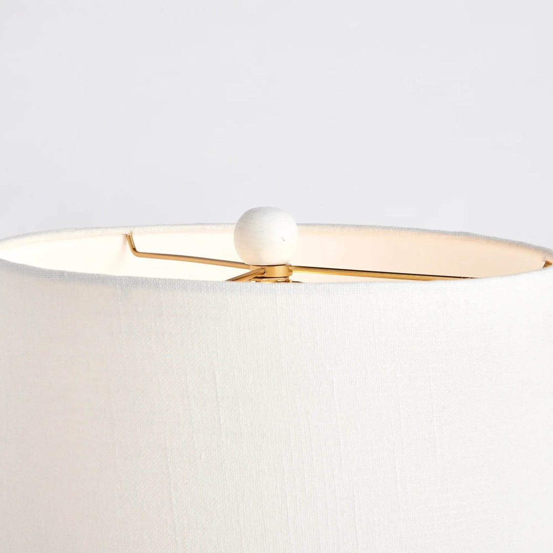 Close-up of mango wood table lamp finial with gold harp and clean white linen shade edge in crisp finish

