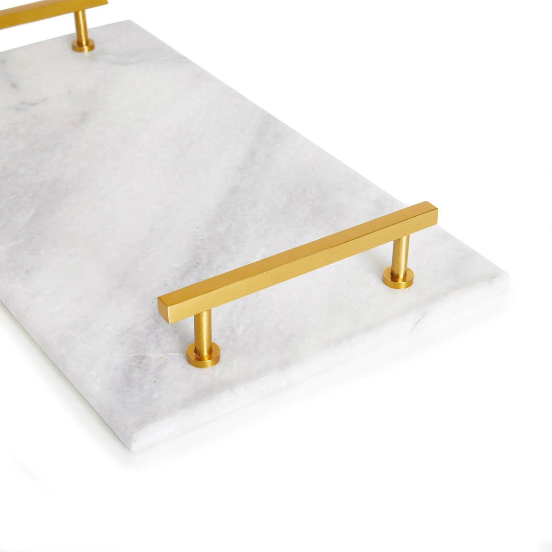 Close-up angled view of gold handle on white marble serving tray, showing natural veining – Coastal Glam.

