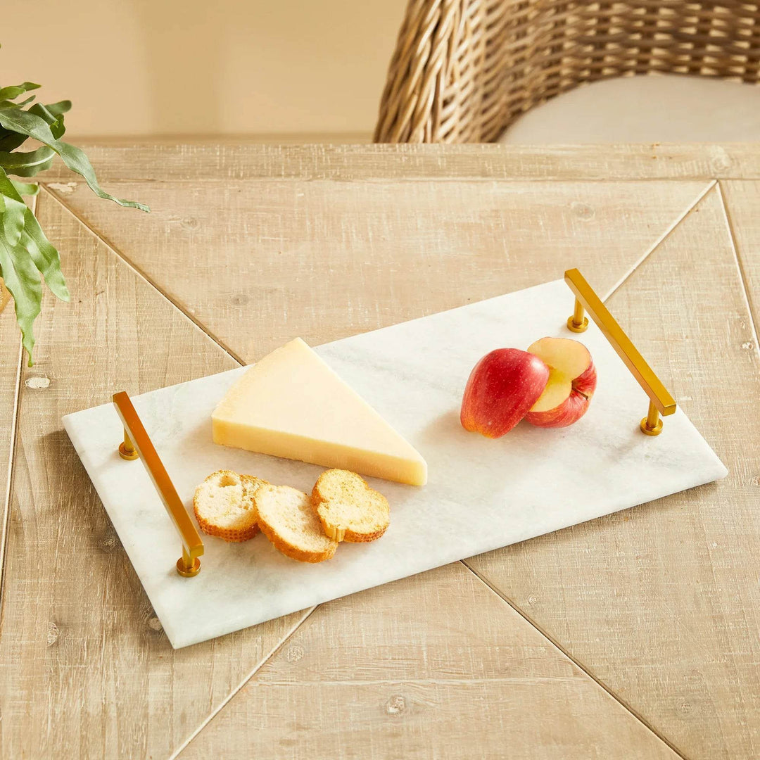 Flat lay of white marble serving tray with symmetrical gold handles on plain white background – Coastal Glam.

