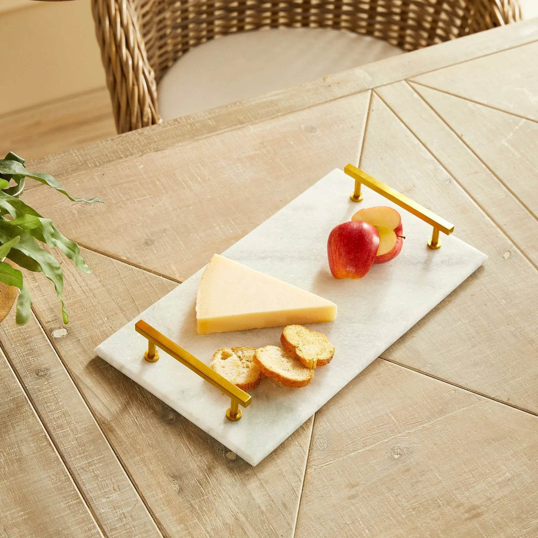 Close-up view with apples and cheese on marble tray, gold handles in foreground – Coastal Glam.

