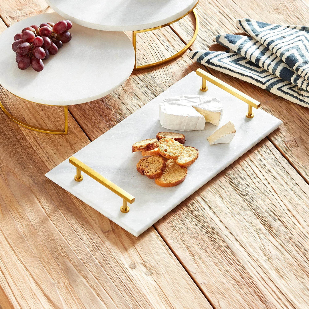 Serving tray with crackers, cheese, and grapes styled on rustic wood table with marble risers – Coastal Glam.

