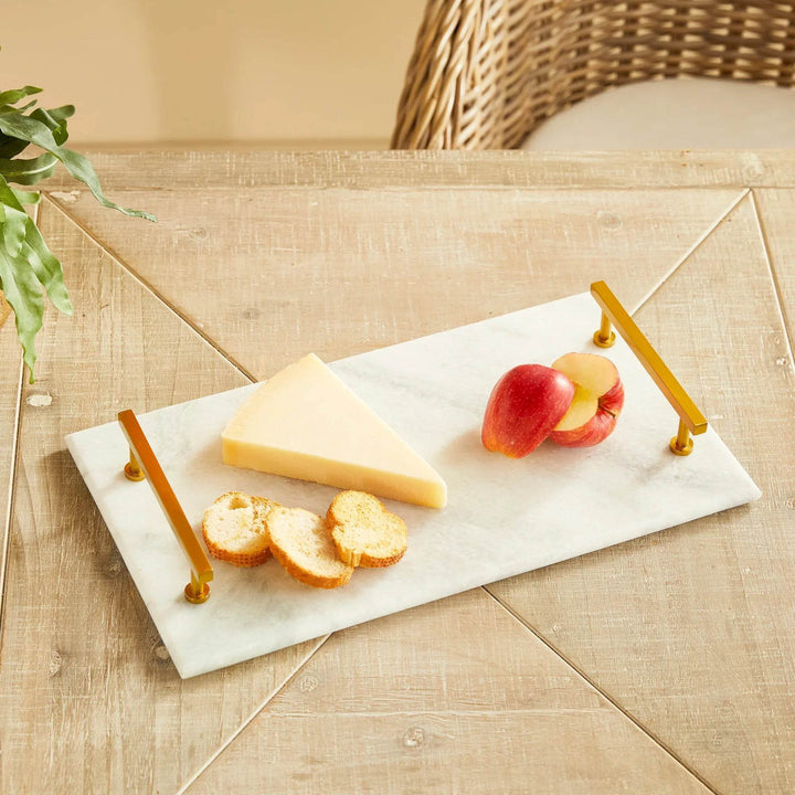 White marble serving tray with gold handles styled with cheese and apples on wood tabletop – Coastal Glam.

