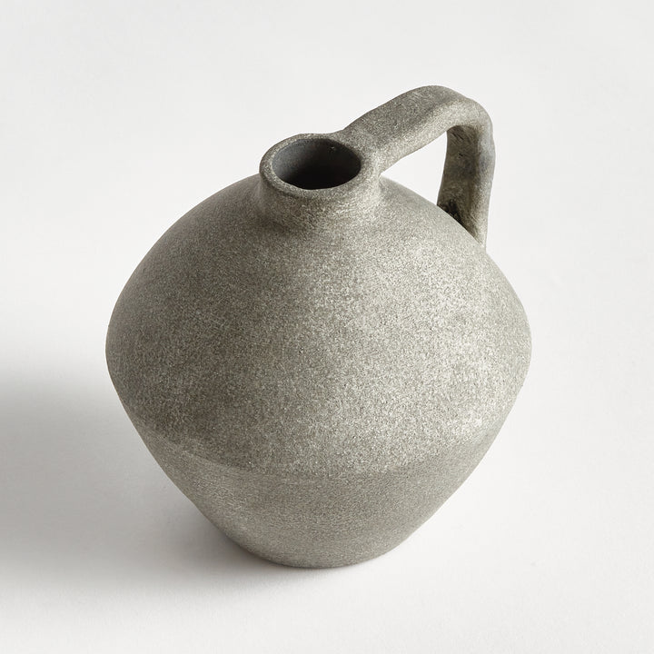 Angled view of a gray terracotta jug vase showing its open short neck, rounded belly and textured surface. Modern Organic