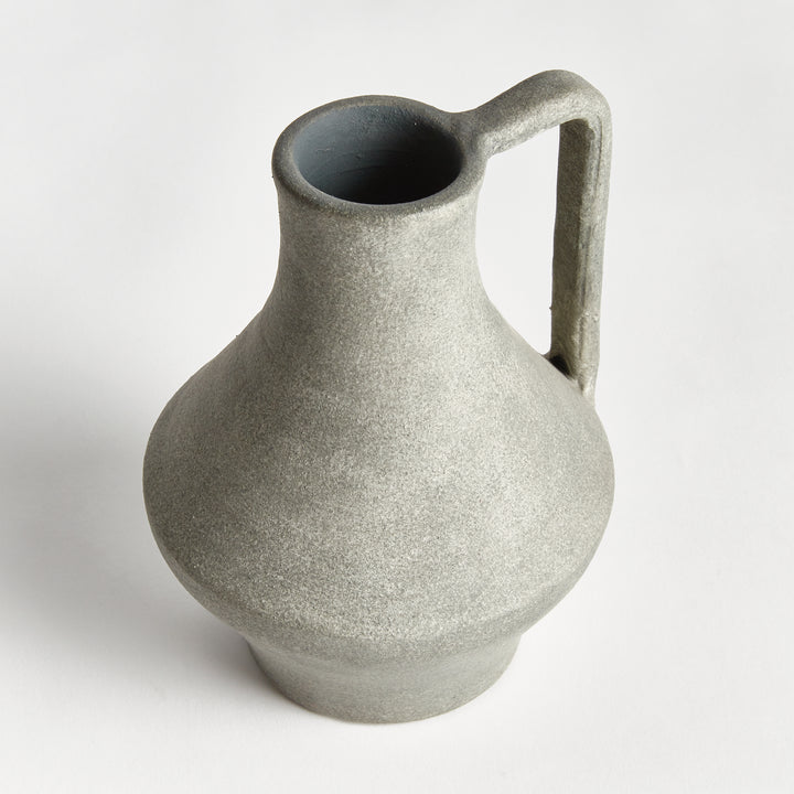 Angled view of a gray terracotta jug vase with a long open neck, flared body and tall handle beside the neck. Modern Organic