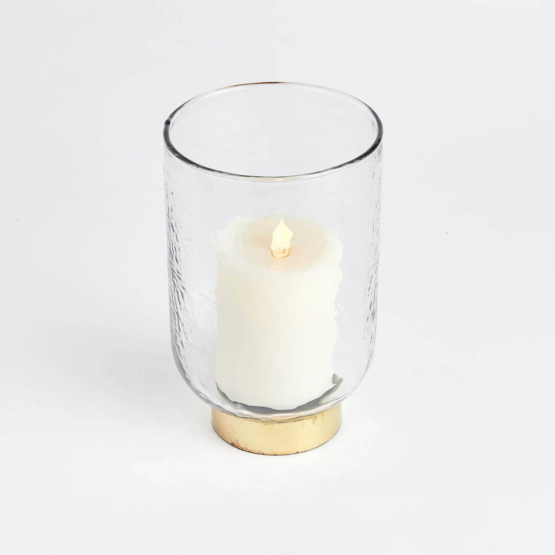 Medium glass hurricane candle holder with hammered texture and gold base, shown with white pillar candle inside – Transitional