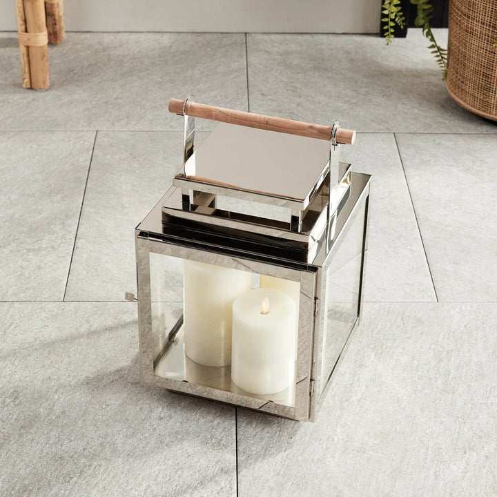 Modern Coastal medium lantern in stainless steel with teak handle shown from an angled perspective