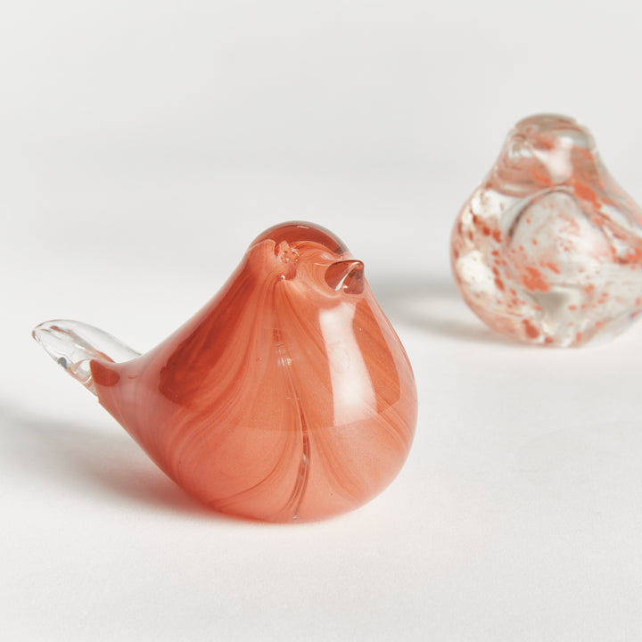 Hand blown melon glass finch sculpture displayed on wood tabletop, translucent decorative bird accent for interiors.