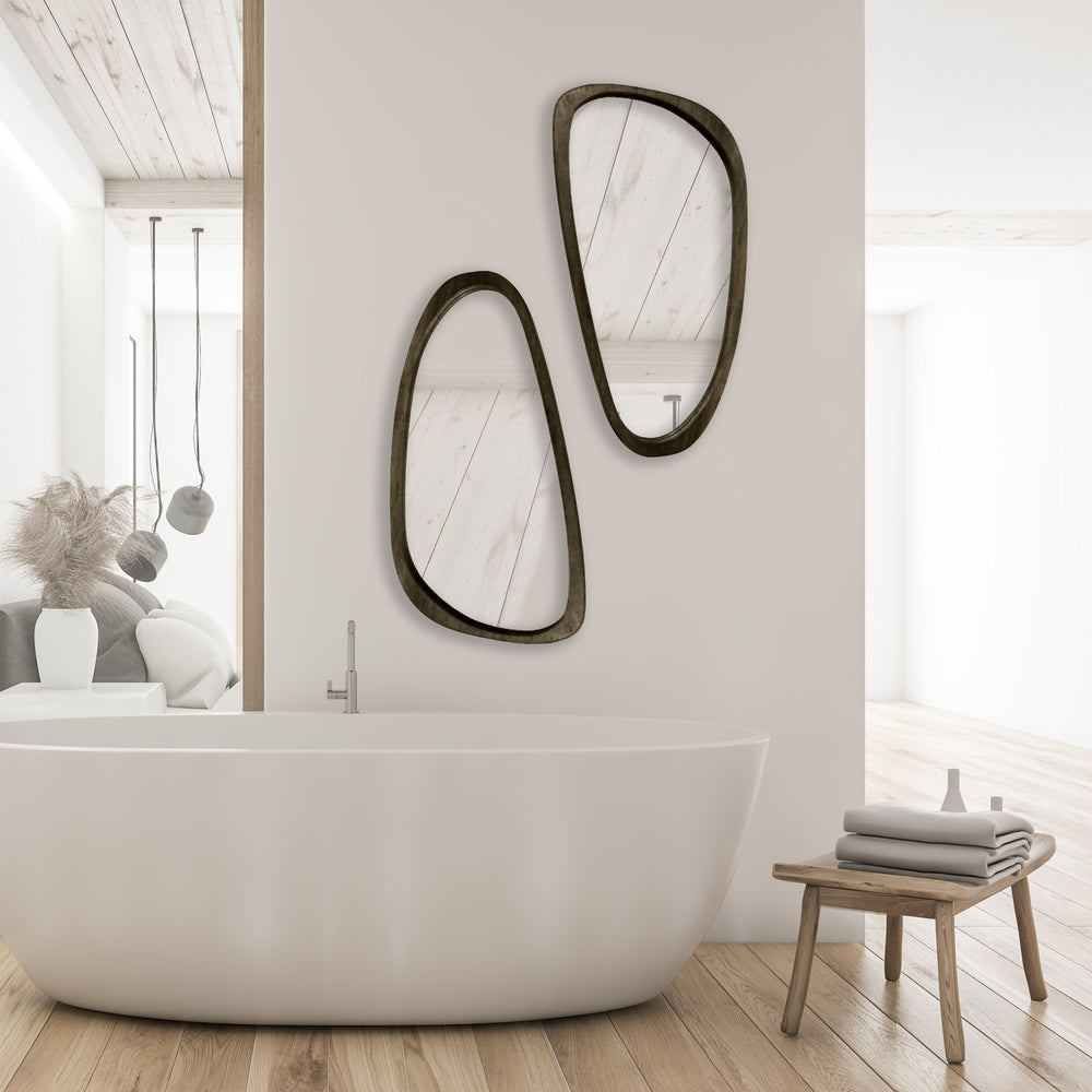 Pair of mid-century modern asymmetrical wall mirrors styled above a tub in a minimalist bathroom with wood and stone accents.

